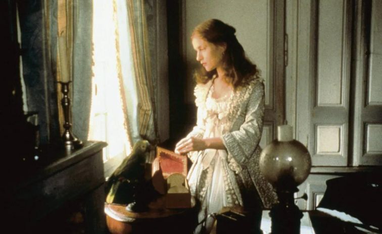 Isabelle Huppert as Emma Bovary looking at the window with a book in hand 