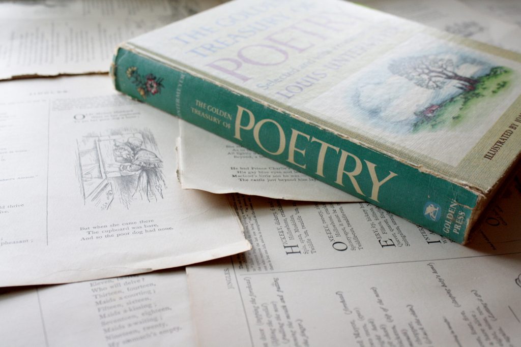 'The Golden Treasury of Poetry' book resting on scattered papers