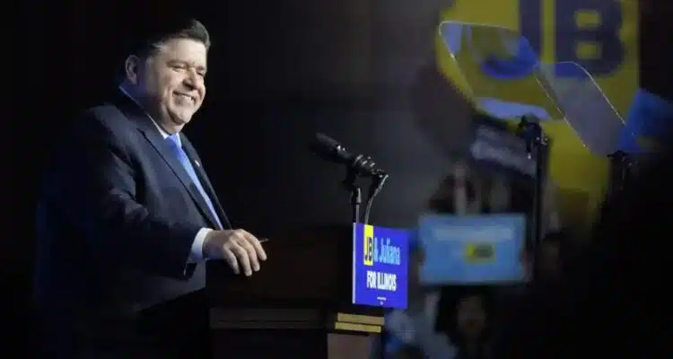 Illinois Governor J.B. Pritzker standing behind a podium giving a speech.