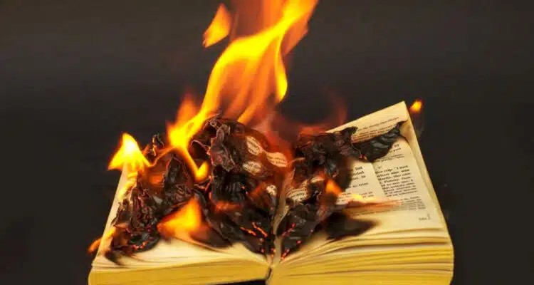 Book burning in front of a black background.