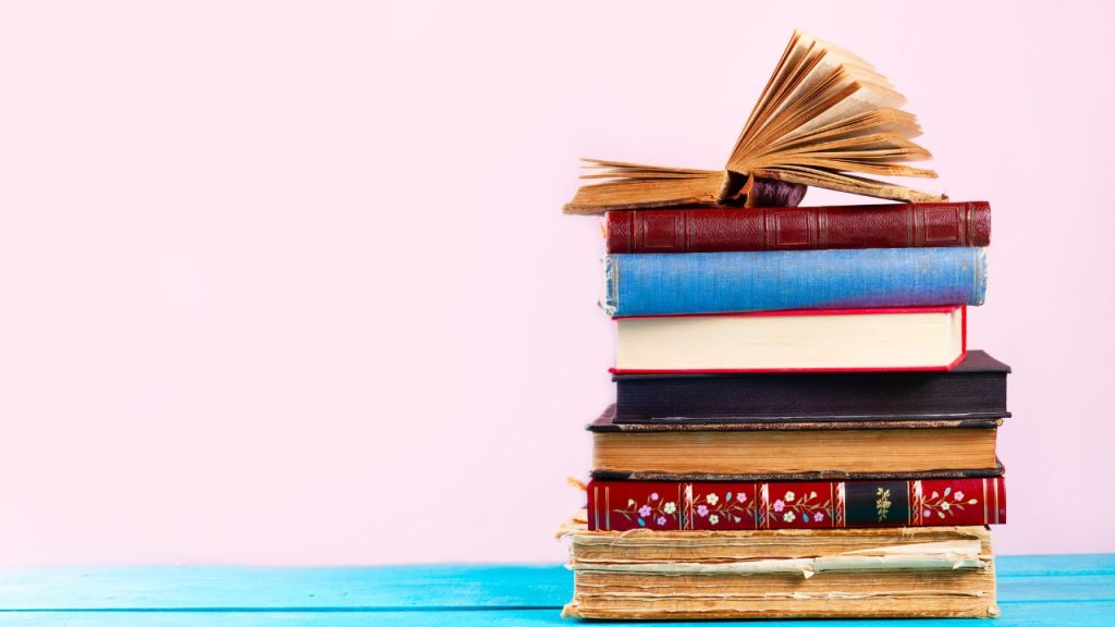 stack of vintage books with one open at the top