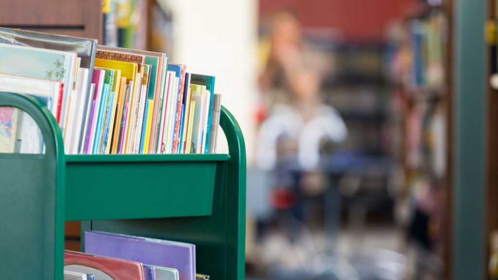 Close-up of a green cart holding a stack of picture books.