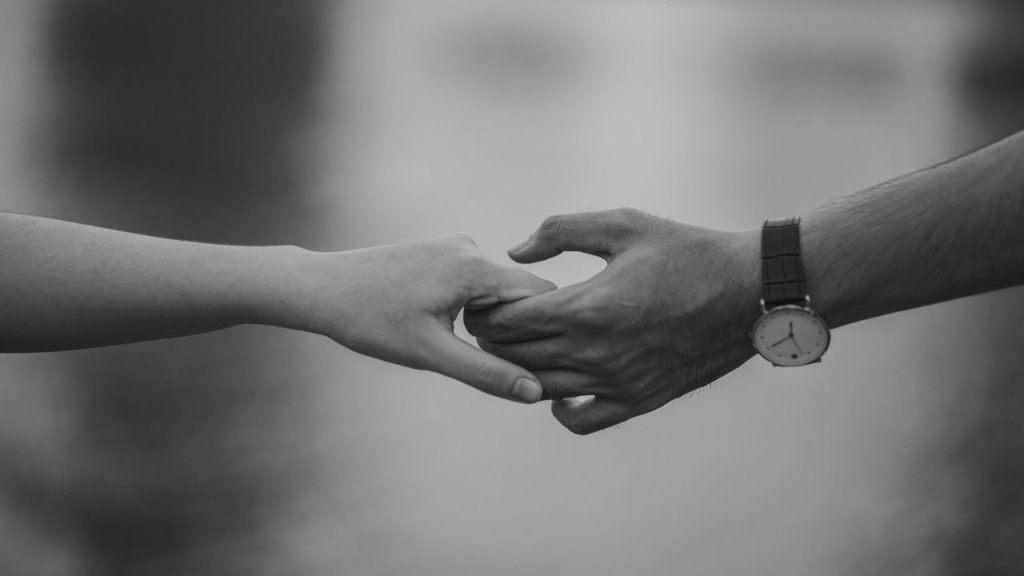 black and white photo of two hands holding