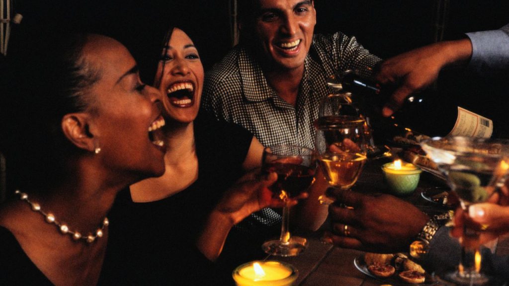 Three people laughing, having drinks and a good time