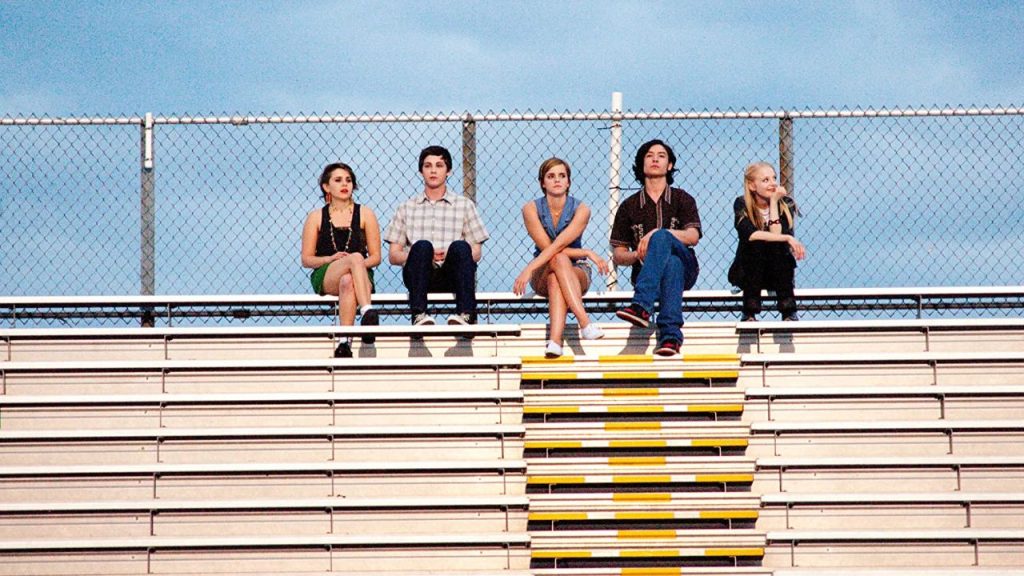 photo of 5 friends from the movie sitting together on the bleachers
