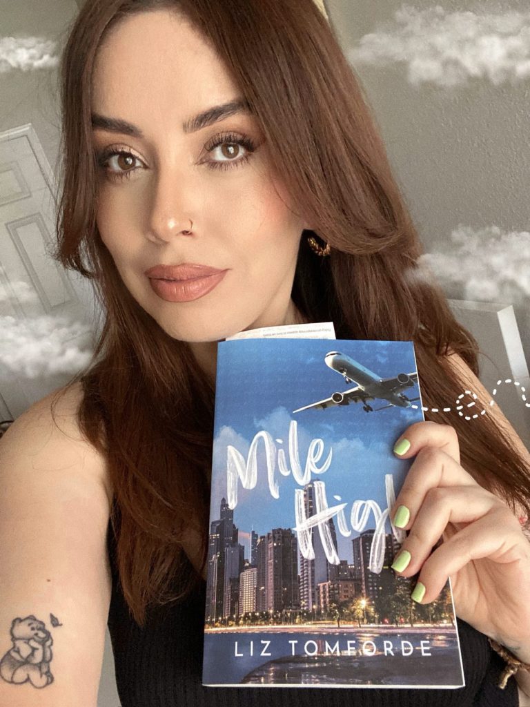 A selfie of Kat holding up a copy of Mile High
