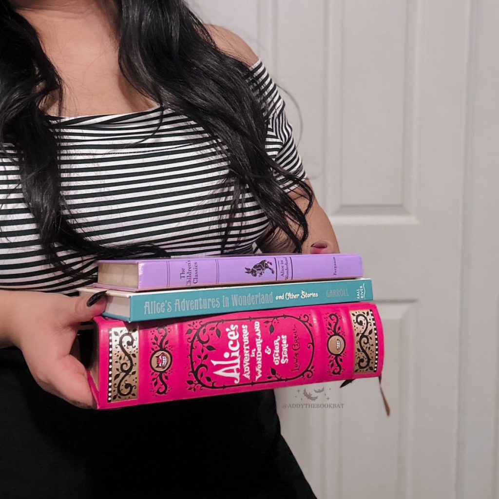 Addy holding a stack of Alice in Wonderland editions