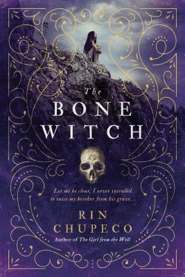 "The Bone Witch" in white text in the center of the cover. A girl in the background since on a mountain outcrop. The cover is purple with golden swirls all around the book. "Rin Chupeco" in yellow and a white skull sit towards the bottom of the cover.