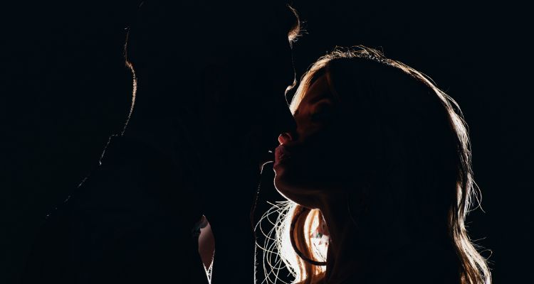 Couple kissing in a darkened room
