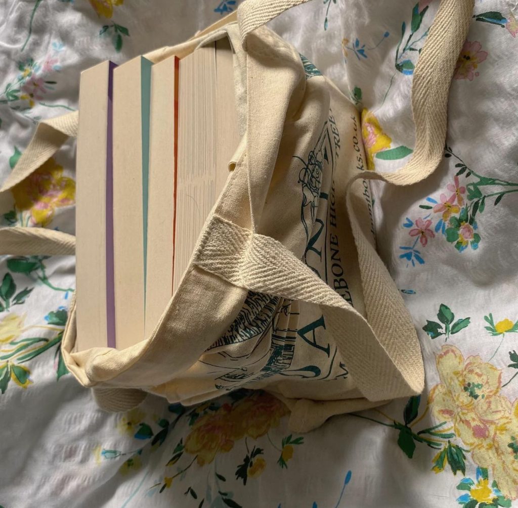 Five books that are backed inside of a canvas tote bag