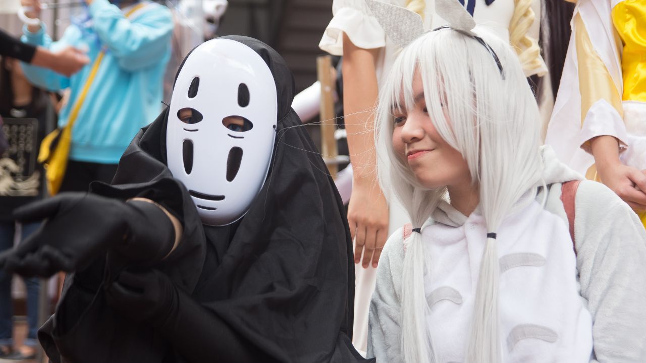 Two cosplayers taking a picture at a fan convention.