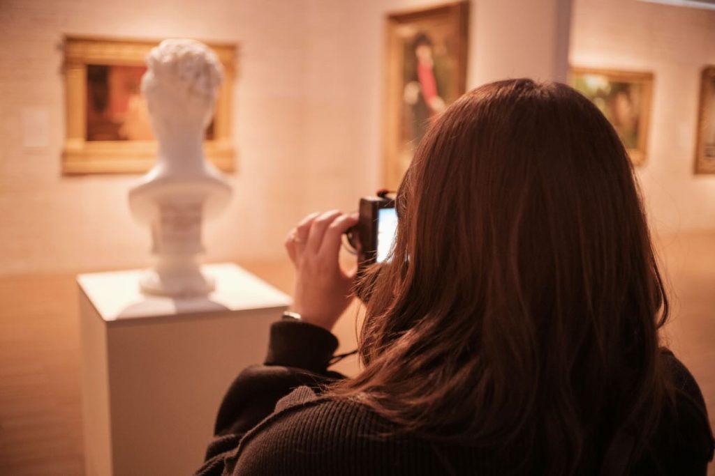 Melgen Munoz taking a picture of a statue in a museum exhibit with her camera