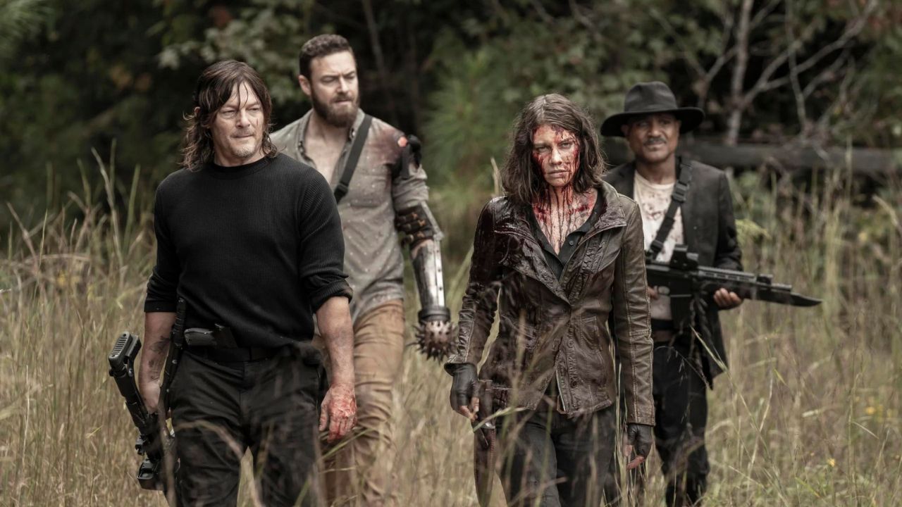 Daryl, Maggie, and two other survivors walk through a grassy field looking haggard.
