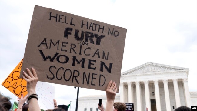 A protest following the overturn of Roe v. Wade and a sign reads "Hell hath no fury like American women scorned."