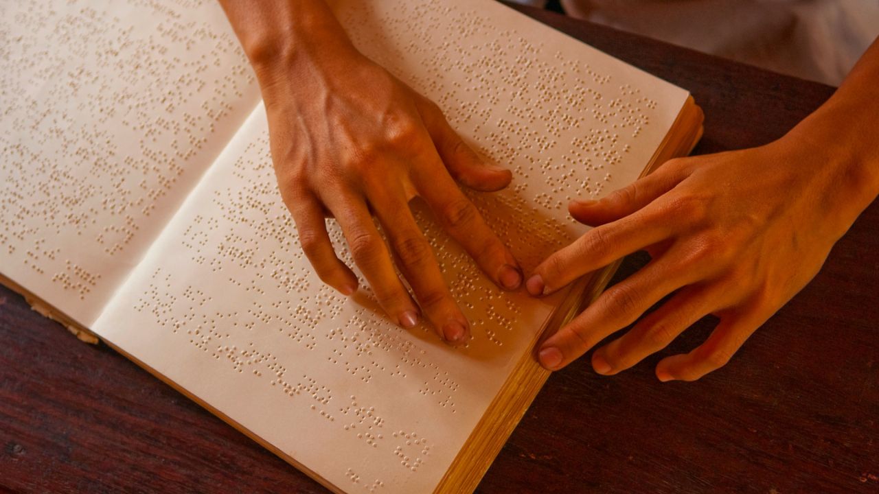 a person reading a braille book