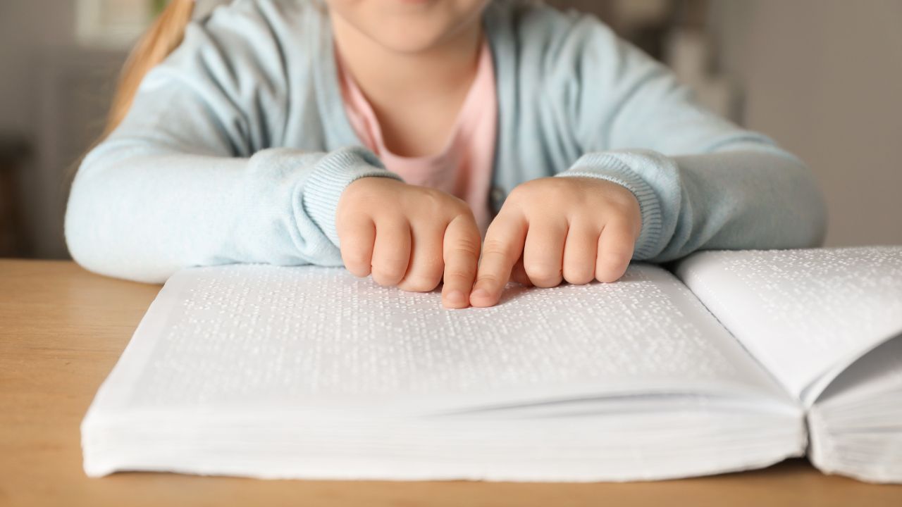 A child reading a Braille book.