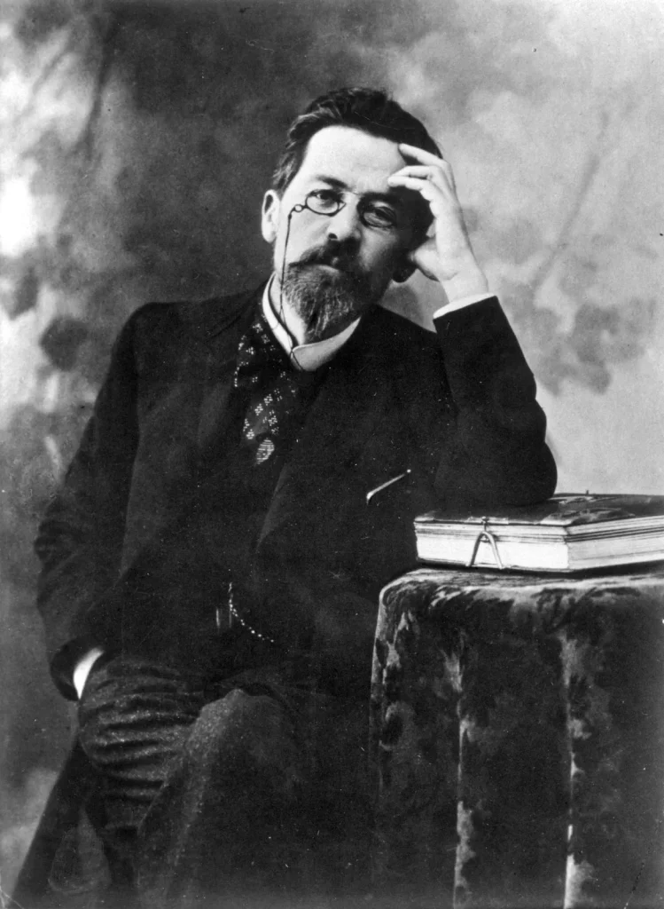 Anton Chekhov with a monocle and a black suit on. 