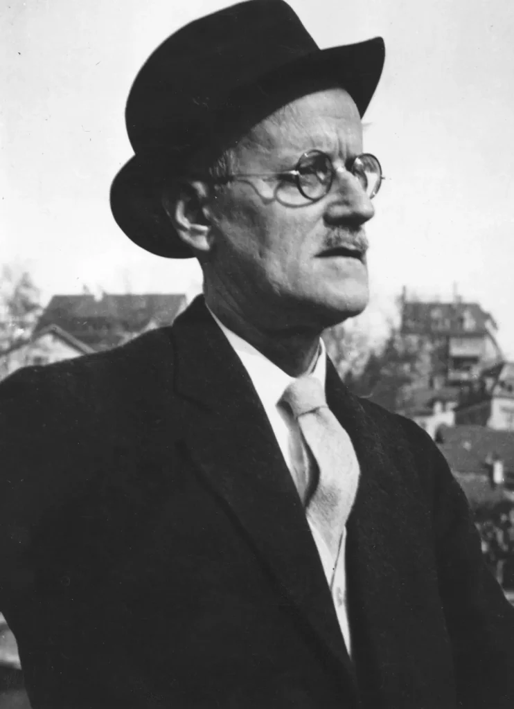 James Joyce wearing a black suit and a black hat.