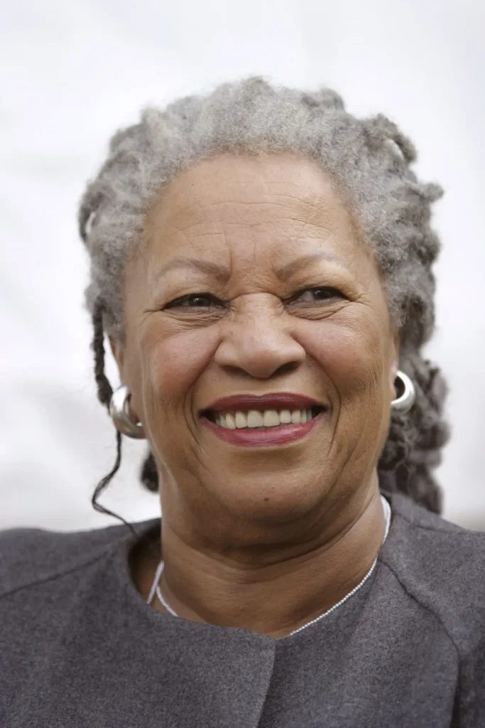 Toni Morrison smiling at the camera with a gray shirt on.