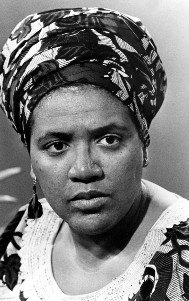Audre Lorde wearing a hair scarf with leaves on it.