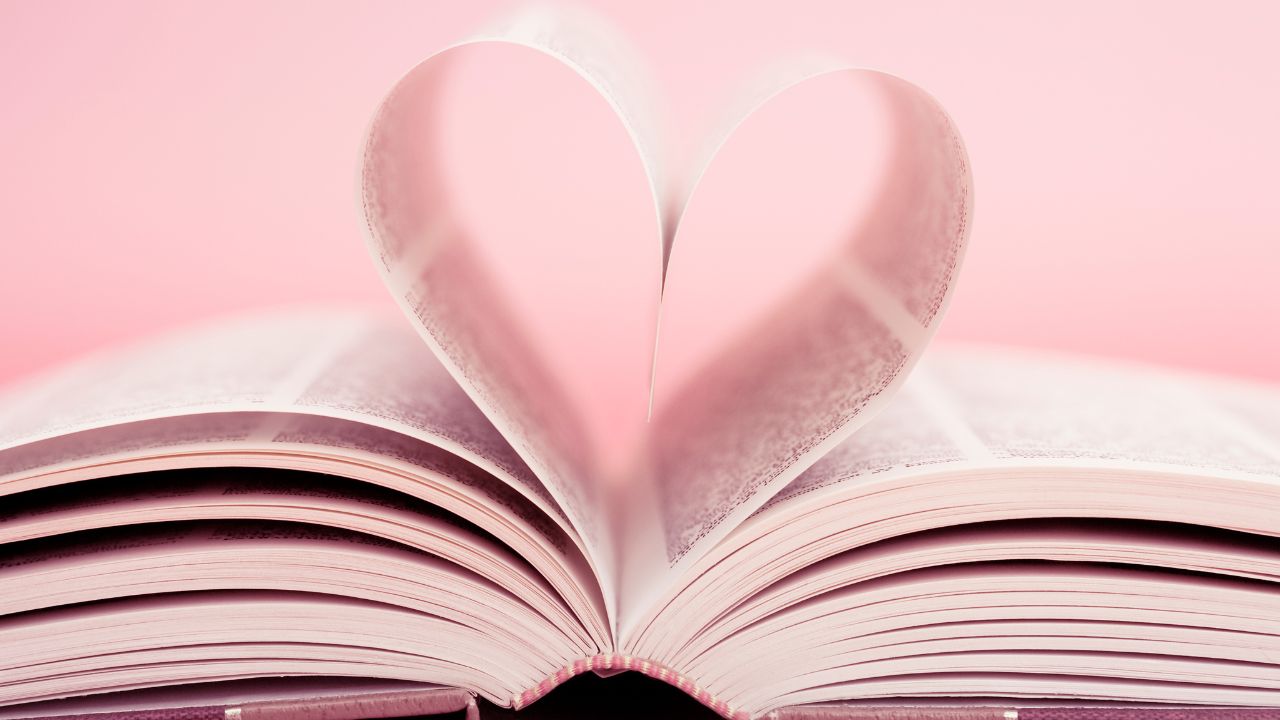An open book with two pages curled up to form a heart.