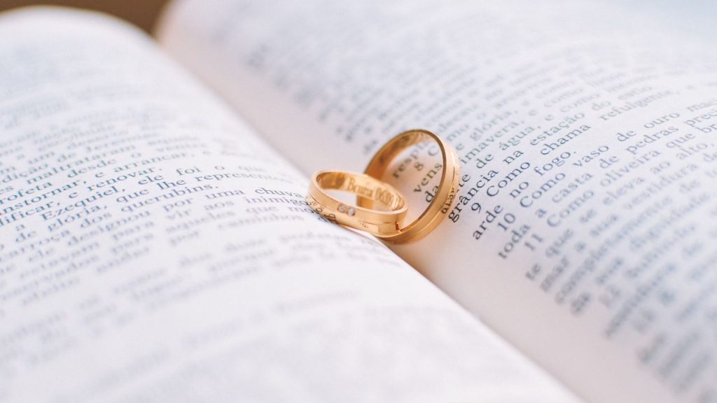 Two gold rings resting in the center of an open book.