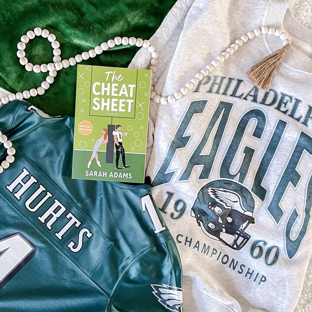 The Cheat Sheer by Sarah Adames over Philadelphia Eagles jersey and sweat shirt with a strand of beads.