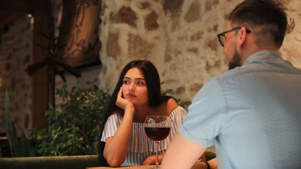 Woman looking bored and disappointed on a date with a man.