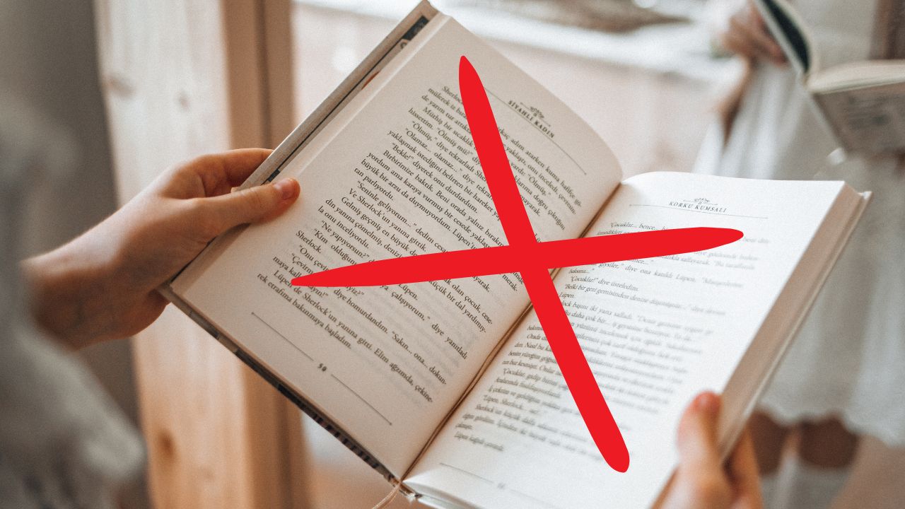 A woman holding an open book with a large X across it.