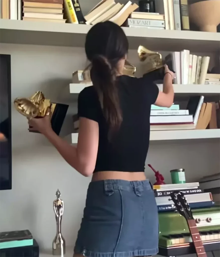Olivia Rodrigo putting her Grammy on her bookshelf