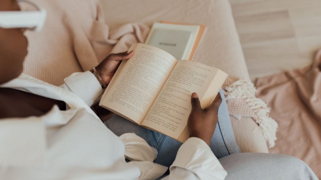 Woman reading a book on the couch.