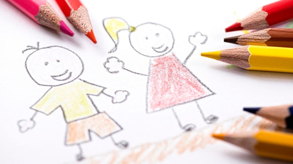 Child's drawing of a boy and a girl surrounded by colored pencils.