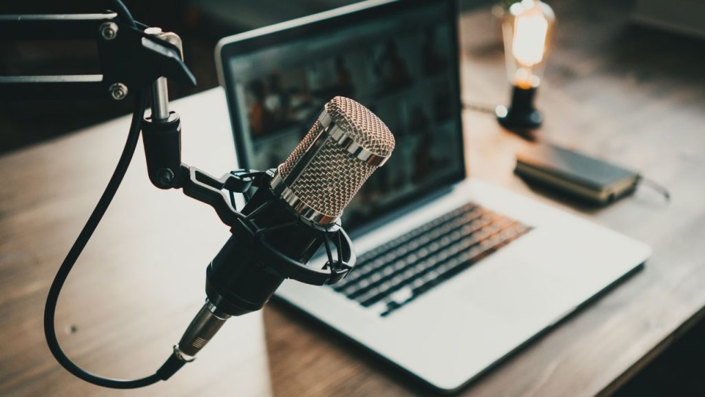 Podcast setup with a microphone next to a laptop.