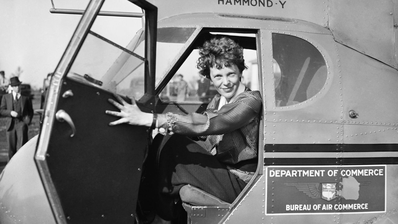 Amelia Earhart leaning out of plane.