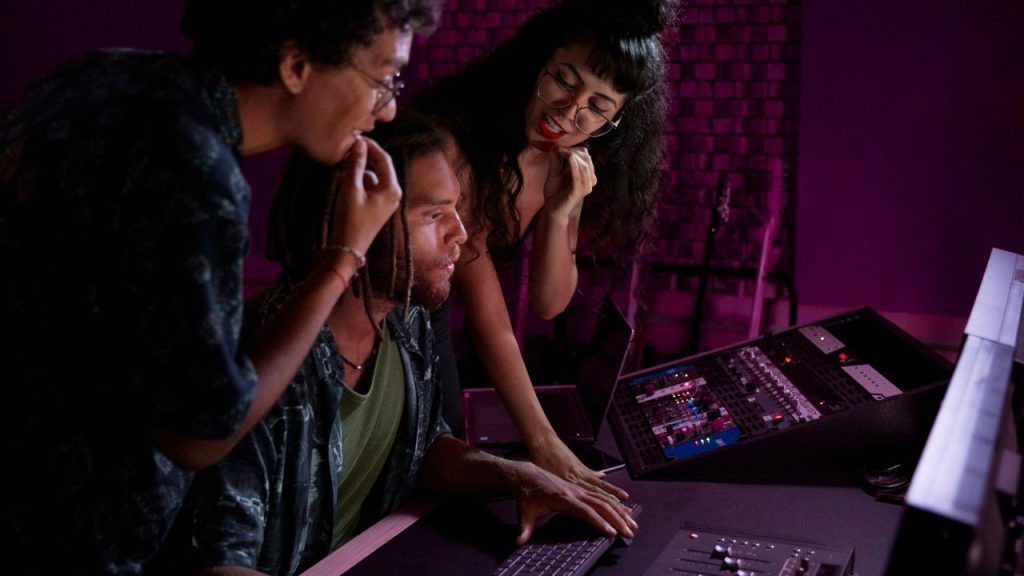 Three people in a producing studio, working on a song