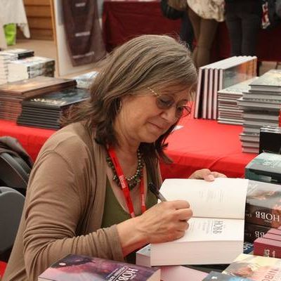 Robin Hobb signing a book at a book signing.