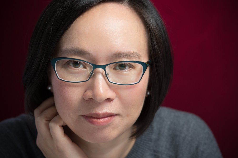 Malinda Lo looking at camera with her hand on her neck.