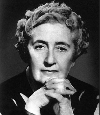 Black and white photo from Agatha Christie with her hands crossed over her chin with a serious look.