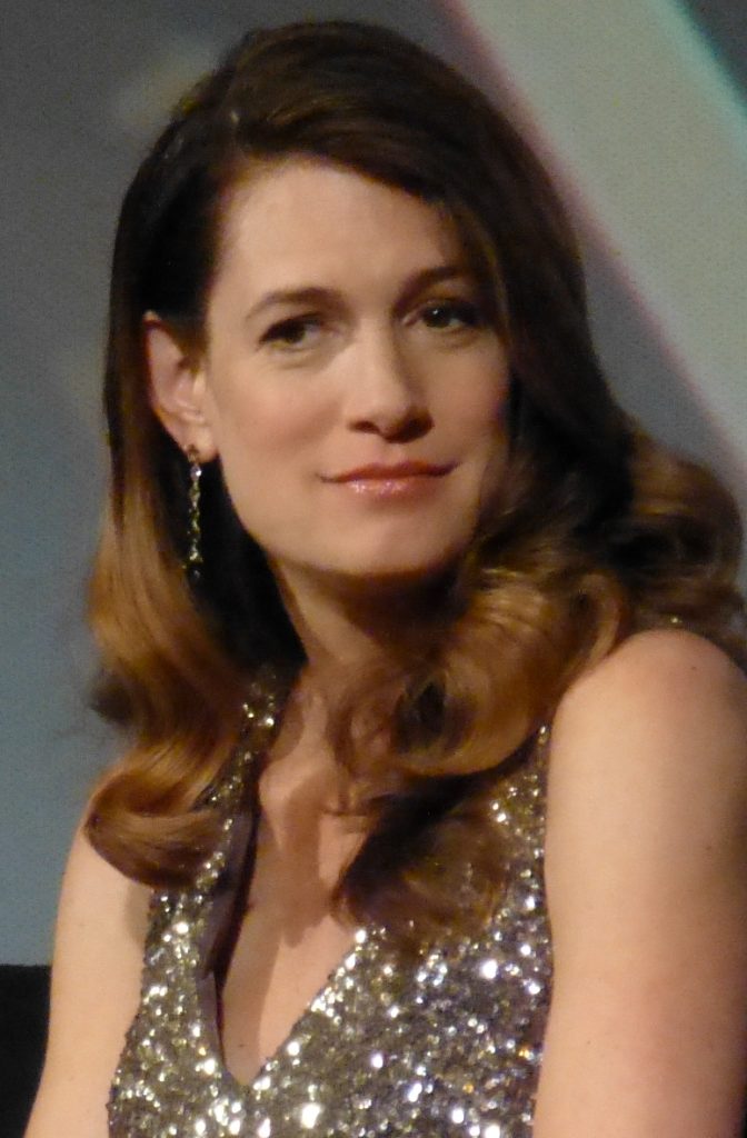 Gillian Flynn wearing a silver sequined top and looking off to the side with a slight smile.