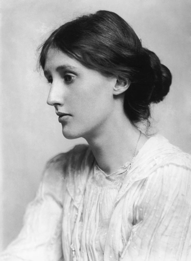 Virginia Woolf wearing a white dress and looking off camera.