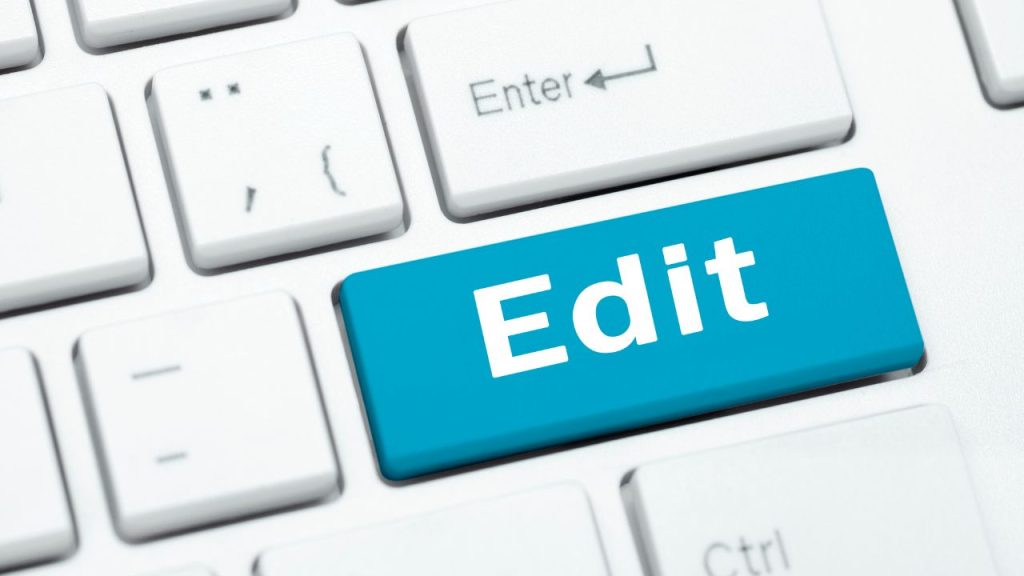 A white keyboard with a blue button in the center with 'Edit' written on it.