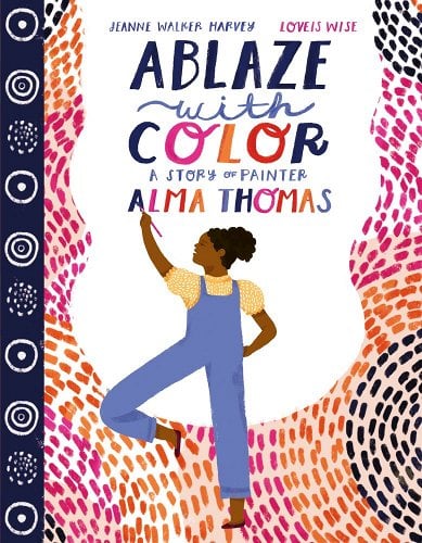 A little girl stands on her right leg as she paints the background of the image with black, orange, and pink colors. Swirls are painted on the left side of the image.