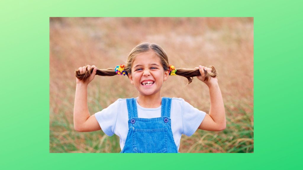 A girl with pigtails on a green background.