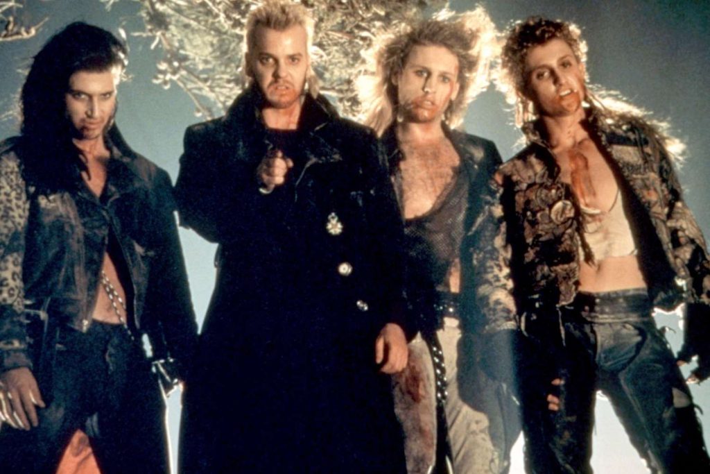 Kiefer Sutherland and the vampire gang from The Lost Boys wearing their 80s clothing with blood all over their faces and chests.