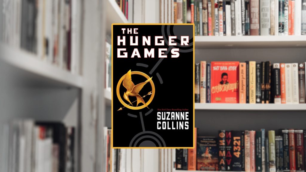 The Hunger Games by Suzanna Collins book cover image with a yellow border, against a set of blurred out bookshelves.