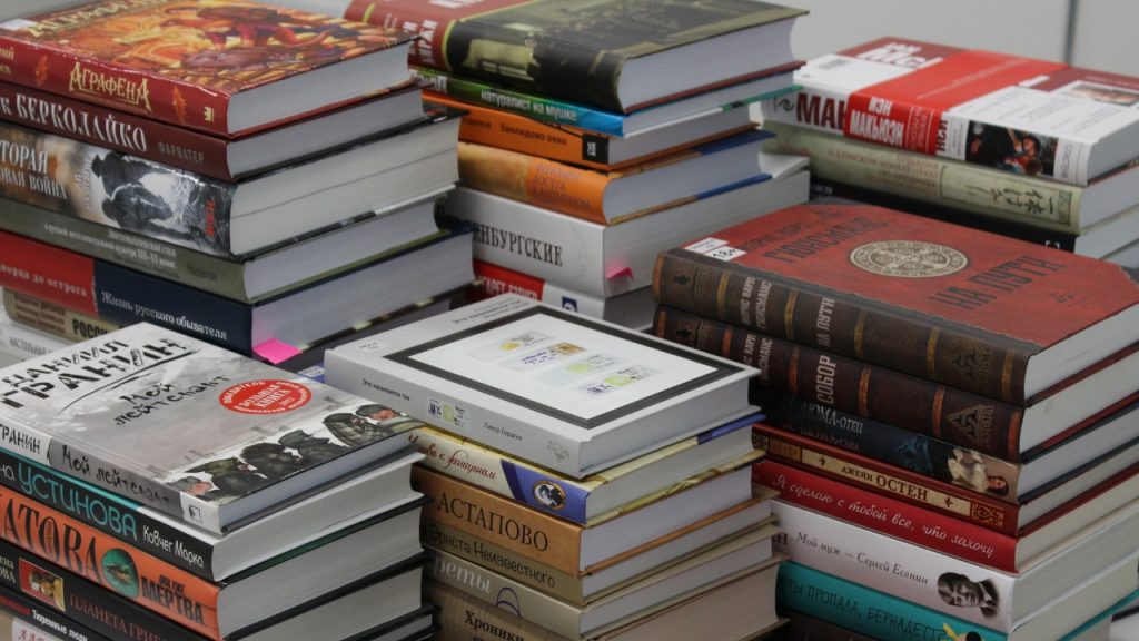 Five piles of stacked hardcover books.