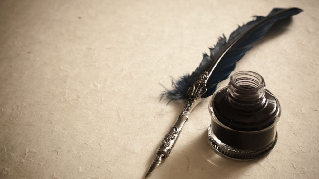 Quill and ink pot on a blank piece of parchment.