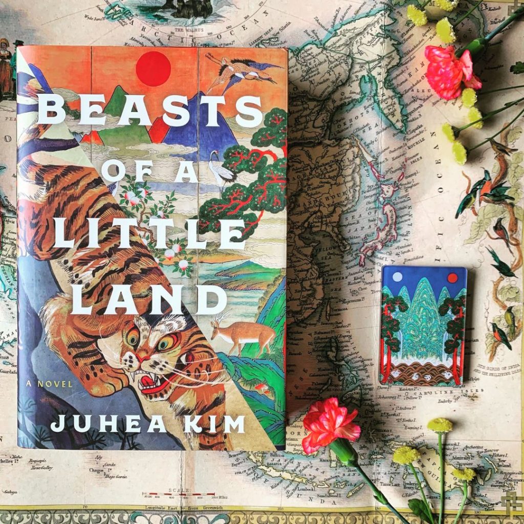 Book cover of Beasts of a Little Land on top of a map with flowers surrounding it.