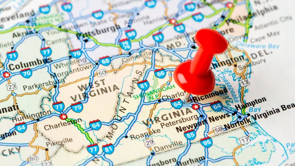 A paper travel map zoomed up to the state of Virginia. A red push is stuck in the middle of the state.
