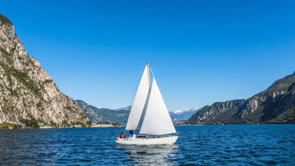 A sailboat in the water with mountains in the background.